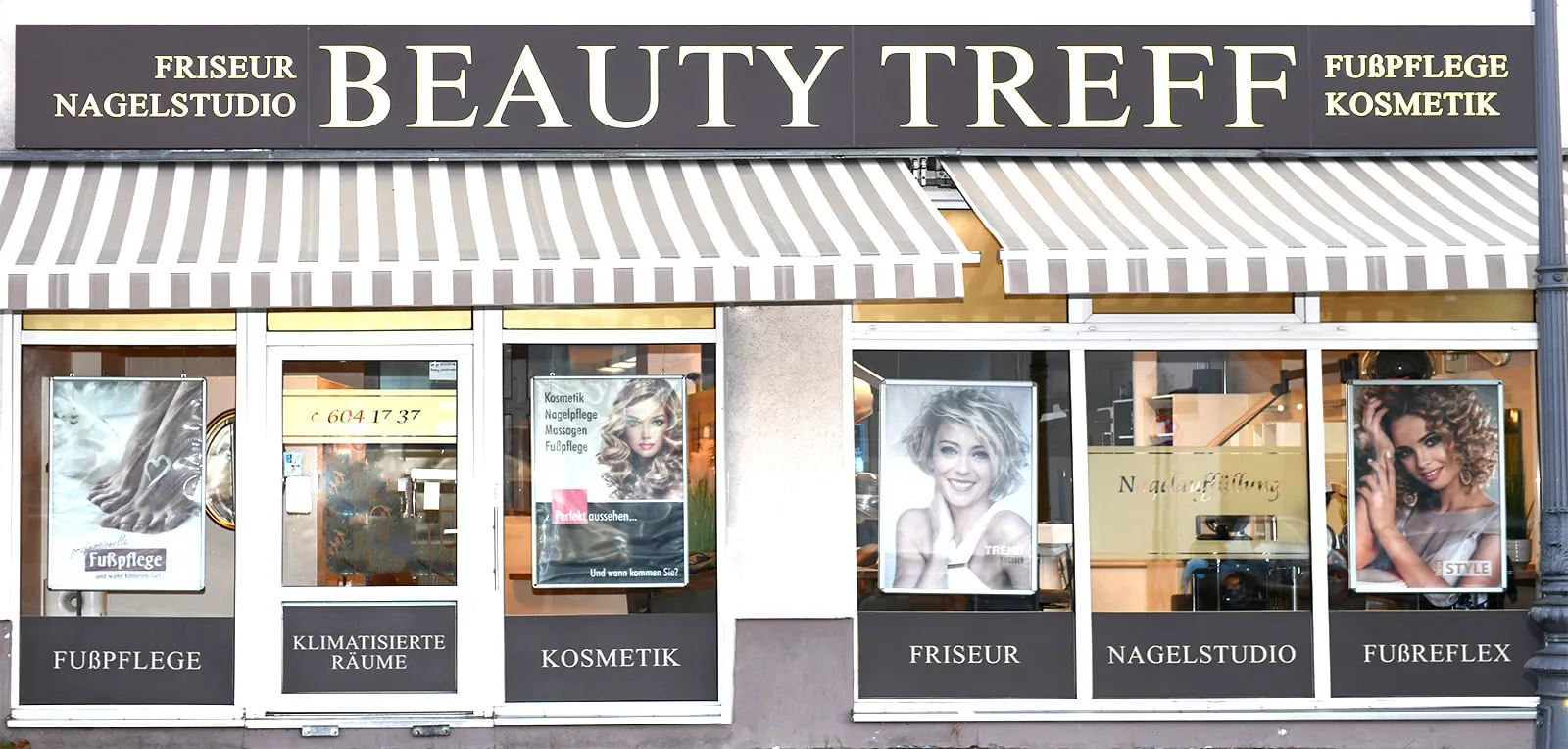 Außenansicht des Beauty-Treff Berlin in Alt-Buckow: Schaufenster mit gestreiften Markisen und dem Schriftzug Beauty Treff